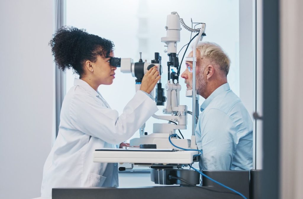Older adult male getting a senior eye exam from his female optometrist.