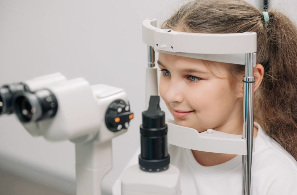 A child gets an eye exam with a slit-lamp from an optometrist for crossed eyes