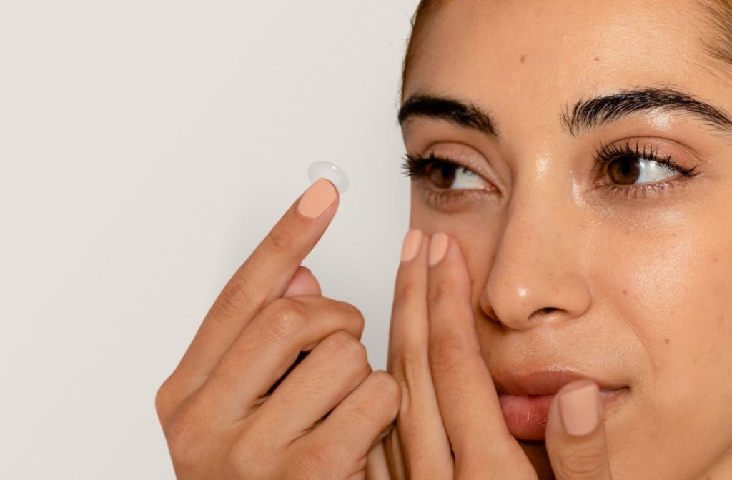 A close up of a woman applying a contact lens.