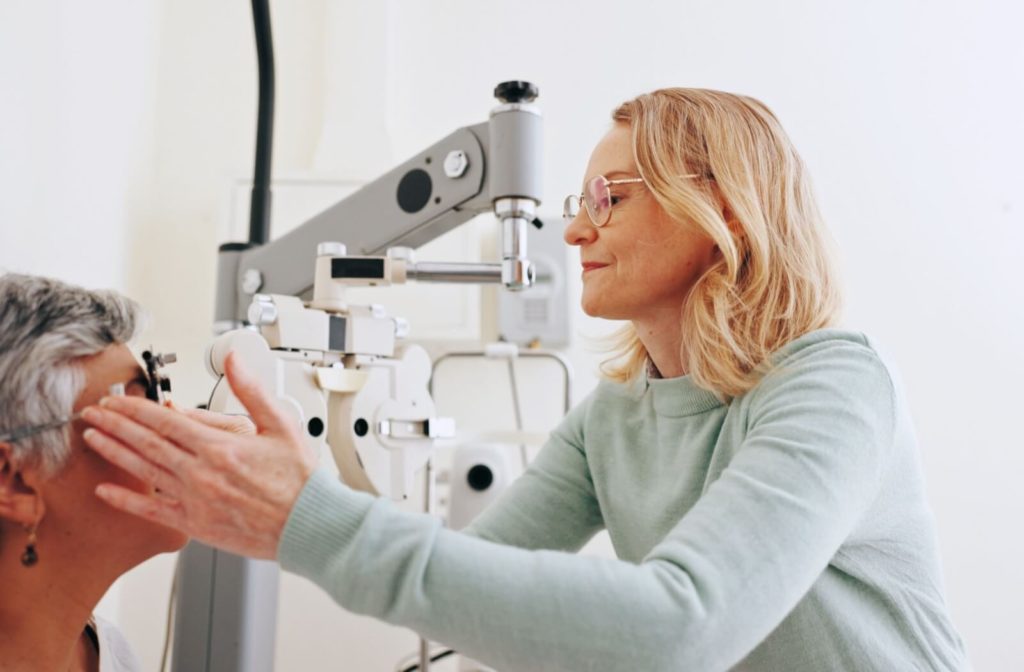 Optometrist examining a patient’s eye with specialized equipment in a bright modern clinic setting