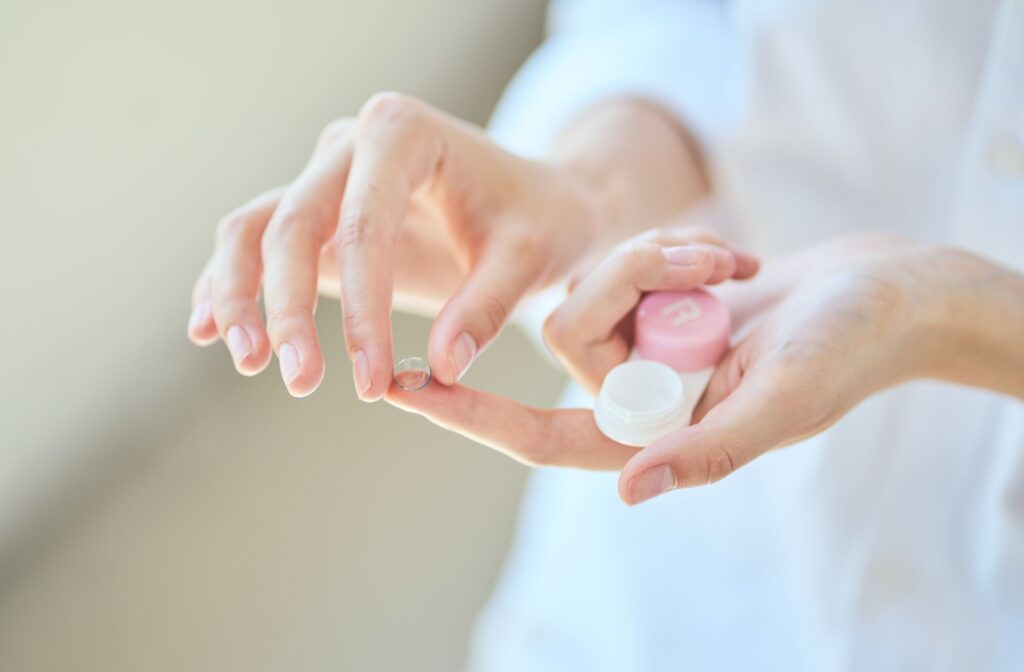 Someone holding a contact lens and the case.