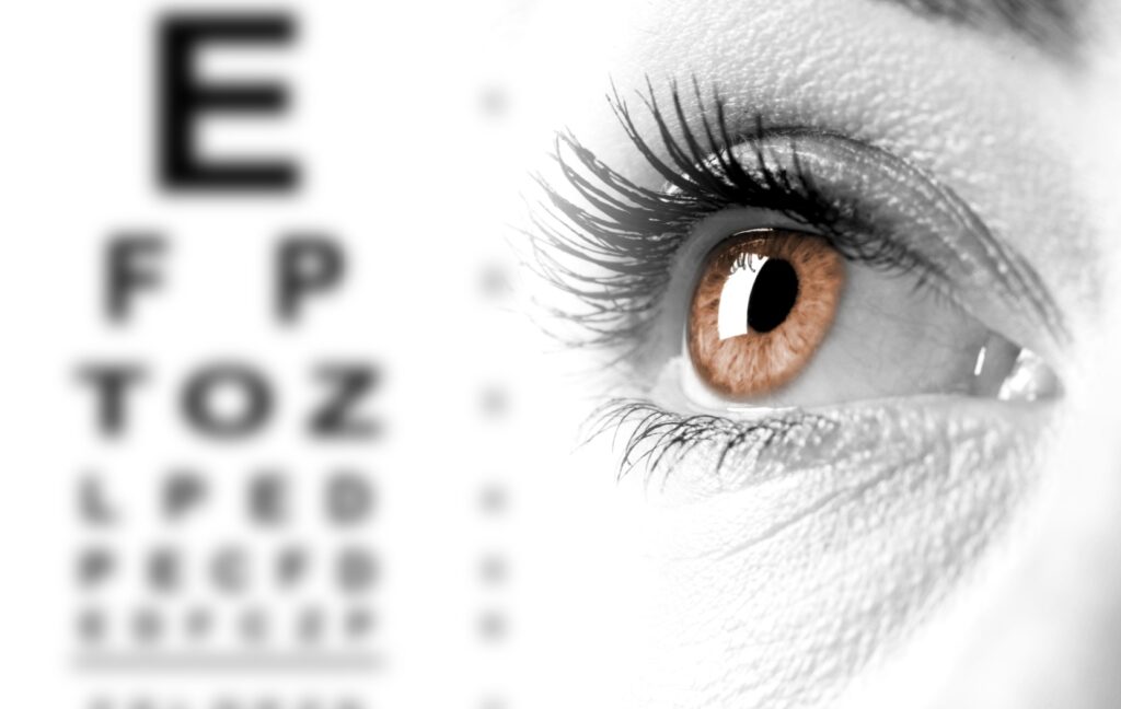 A blurred Snellen eye chart, illustrating the effects of myopia, appears beside a close-up of a brown eye.