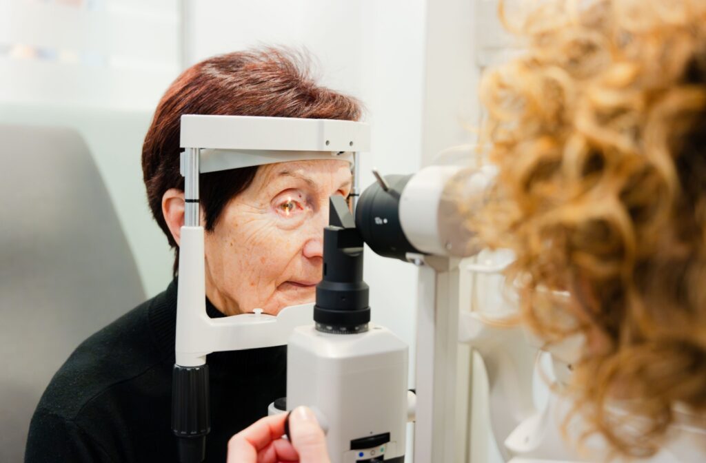 A senior person getting a slit eye test done during a routine eye exam
