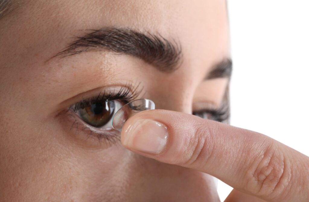 A close up of a person putting contact lens in their eyes