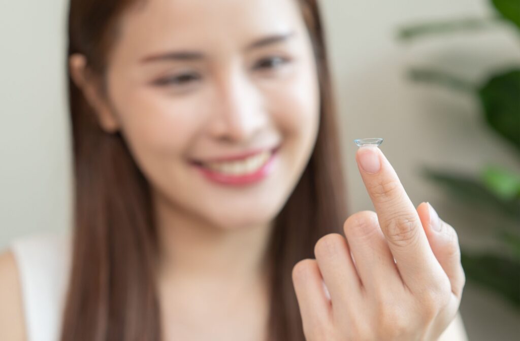 A person looking at a contact lens on their finger