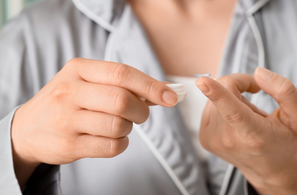A person holding a contact lens on the tip of their finger