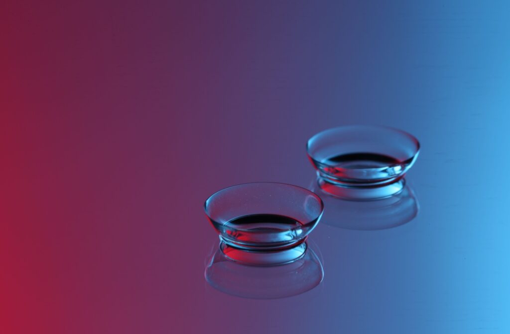 A pair of contact lenses resting on a blue and purple background